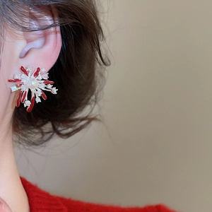 Close-up of elegant red fireworks stud earrings with zircon and pearl on model