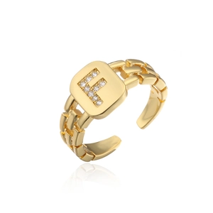Detail of adjustable gold ring with Zirconia letter F and chain texture band