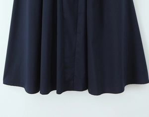 Gros plan de l'ourlet de la robe bleu marine montrant le tissu et les plis drapés