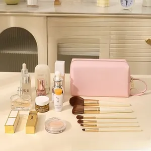 Pink PU leather makeup bag showing large capacity with skincare products and brushes