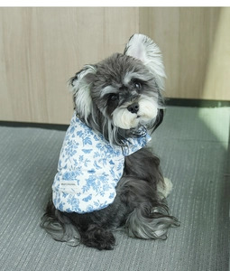 Close-up of blue floral pet vest with Smiley Original label and leash ring detail