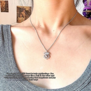Close-up of lily of the valley necklace with pearl and bow pendant on neck