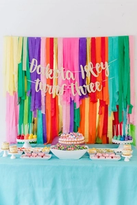 Vibrant crepe paper streamers backdrop with personalized Dakota Isley birthday banner