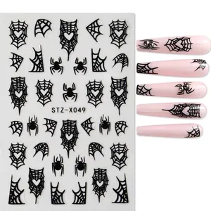Detailed view of Halloween nail stickers featuring black spider webs and heart motifs