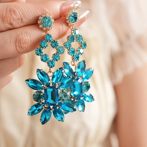 Détails de boucles d'oreilles vintage dorées avec cristaux bleus en forme de fleurs