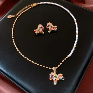 Detail of 18K gold-plated horse jewelry set with colorful zircons on black leather
