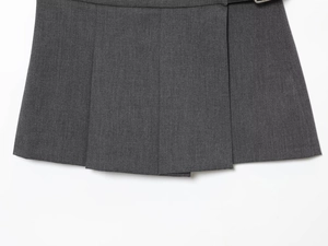 Détail de la jupe-short grise plissée montrant la texture du tissu et les plis