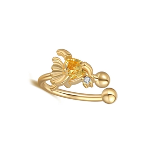 Detail of gold ear cuff featuring a bright yellow triangle zircon and sea-style charm