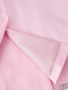 Close-up of pink satin fabric texture showing smooth surface and matching inner lining