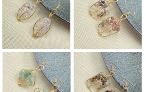 Detail of four handmade wire-wrapped crystal earrings with natural amethyst and tiger eye
