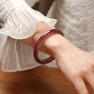 Close-up of a vintage cat eye stone bracelet in dark purple on a woman's wrist