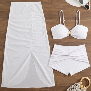 Detailed flat lay of white three-piece swimwear with mesh skirt and golden ring detail