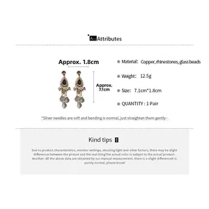 Detail showing vintage long drop earrings with water drop rhinestones and glass tassels