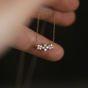 S925 sterling silver gold clover necklace with sparkling diamonds held in hand