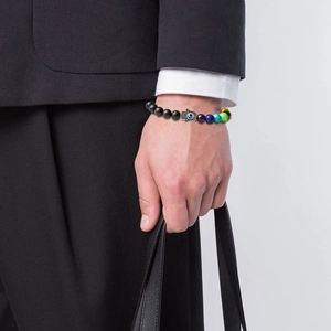 Détail du bracelet perlé Main de Fatma et Œil Bleu porté avec un costume noir homme