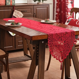 Red festive lace table runner with hollow patterns and tassel decor for Christmas party