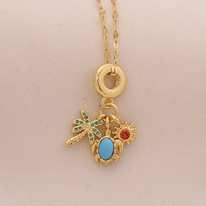 Close-up of golden necklace with palm tree, sea turtle and sun pendants set with colorful gems