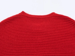 Detail of red crew neck knitted sweater featuring textured vertical ribbed patterns