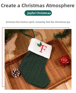 Close-up of a green knitted Christmas stocking with an embroidered red letter F