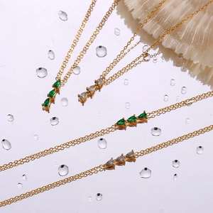 Detail of 18K gold plated necklaces and bracelets featuring triple pear-cut zircon pendants