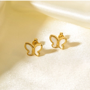 Detail of 18K gold butterfly earrings with white shell inlay on beige silk fabric