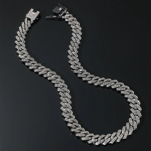 Close-up of hip hop silver cuban link necklace with iced out crystals on black background