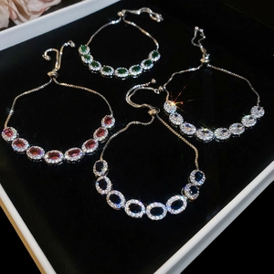 Détail de bracelets réglables en argent avec pierres précieuses ovales émeraude et saphir