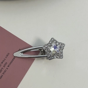 Detailed view of a silver star hair clip with pink rhinestones on a metal base