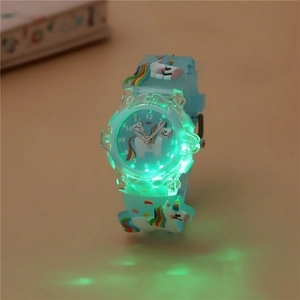 Macro detail of kids glowing unicorn watch showing bright green LED lights in dark