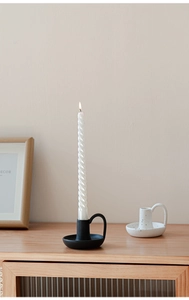 Dettaglio del portacandele in ceramica nera con candela a spirale per decoro tavola