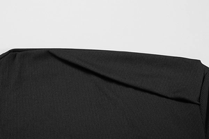 Detail of black ribbed knit fabric showing the textured vertical stripes and tight material