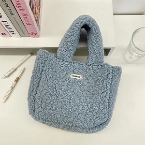 Detail of light blue fluffy fleece tote bag with Sozakka brand label on white desk