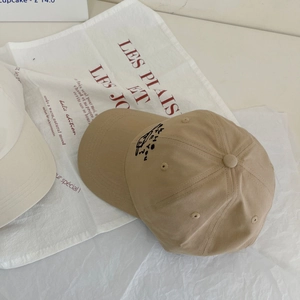 Detail einer khakifarbenen Basecap-Seite mit minimalistischer Stickerei auf Baumwolle