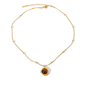 Detail of vintage gold necklace with brown gemstone pendant and small pearl accents