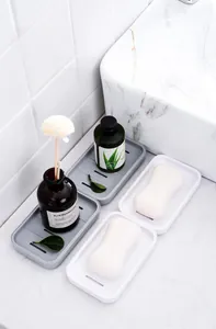 Close-up of dual-layer draining soap box showing the grid rack and tray on bathroom tiles