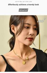 Detailed view of a gold mixed-link titanium necklace with heart and engraved disc charms