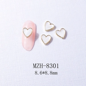 Detail of 8.6x8.8mm heart nail charms with gold metal edges and pearl texture inlay