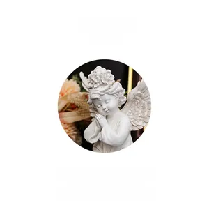Macro detail of white resin praying angel sculpture with flower headband and wings
