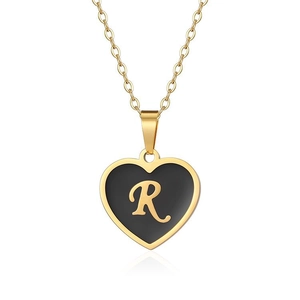 Detail of golden heart pendant featuring black enamel finish and the letter R on a thin chain