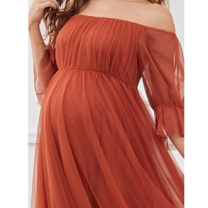 Detail view of the multi-layered tulle fabric on a maternity gown over a baby bump