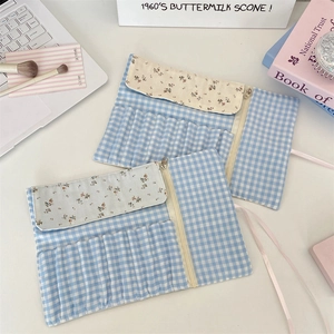 Detail of floral makeup brush pouch showing zipper pocket and multiple tool slots