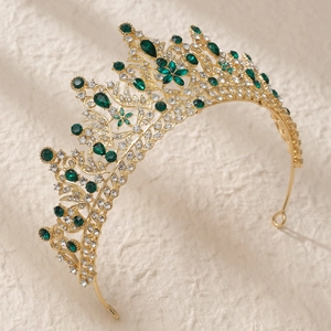 Detailed macro shot of gold bridal tiara with green rhinestones and floral alloy patterns