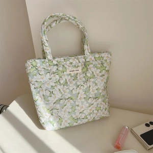 Detail of floral quilted tote bag with simple wish label and soft natural lighting