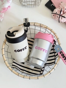Detail view of portable stainless steel coffee mugs with carrying straps in a basket