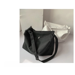 Detail of minimalist black and white canvas messenger bags with durable shoulder straps