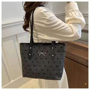 Detail der grauen Polka-Dot-Einkaufstasche mit Metallschleife und Schleifenstickerei