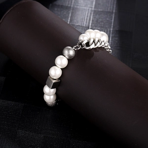 Détail du bracelet en perles et chaîne en acier titane argenté sur un support