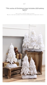Close-up of mini snowy Christmas tree with LED lights and natural wooden base decoration