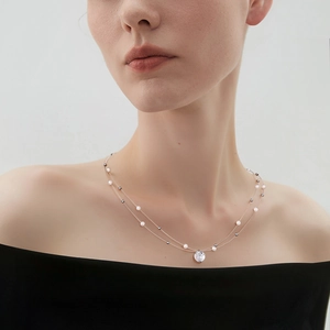 Close-up of double-layer necklace featuring a sparkling zircon pendant and delicate white pearls