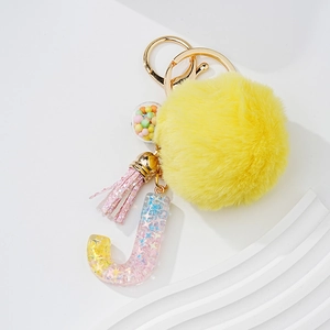 Star sequins resin letter J keychain with yellow pompom and pink tassel on gold hardware